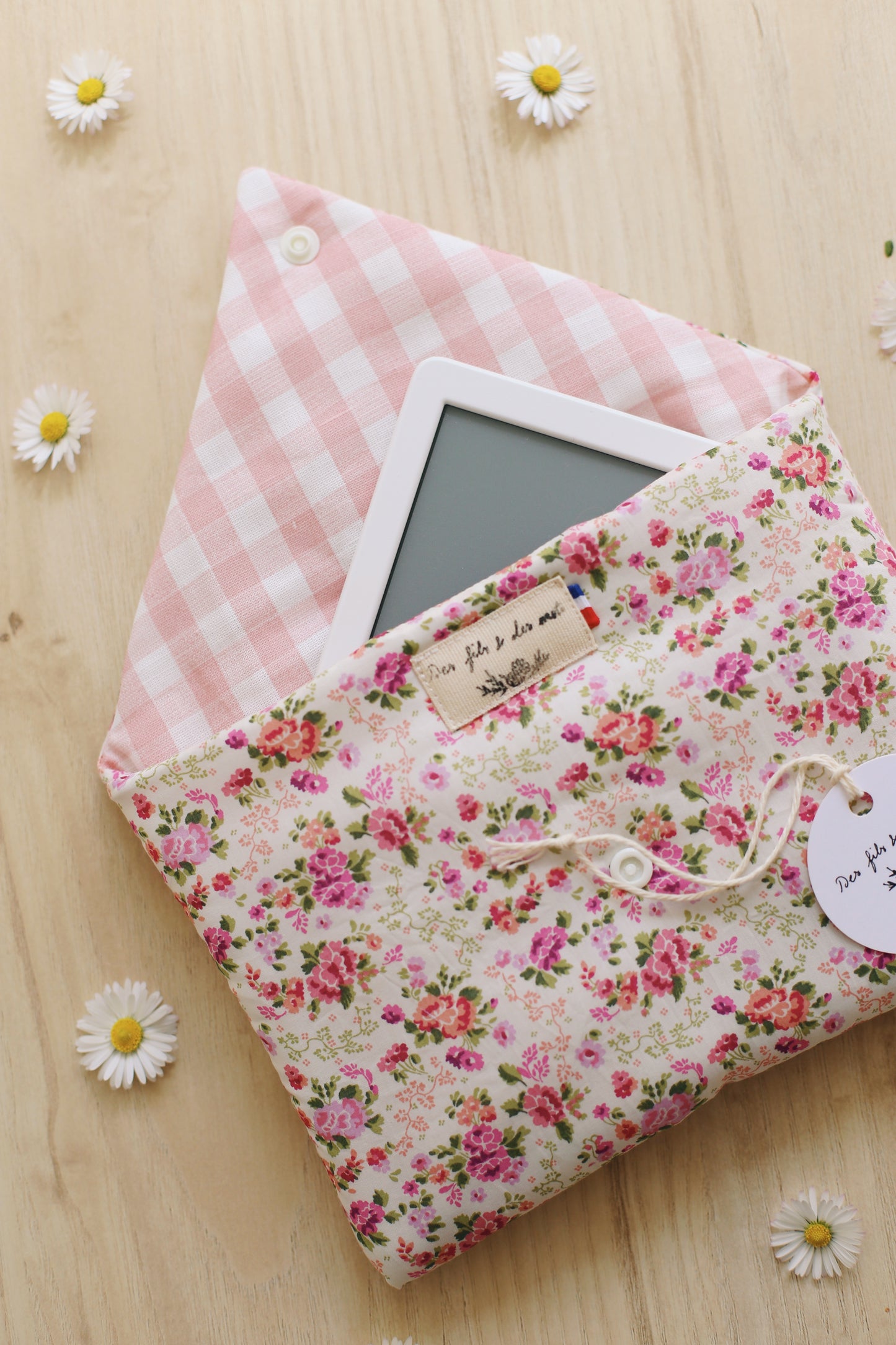 Housse pour liseuse Liberty of London ouverte, doublure vichy rose poudré, liseuse Kindle glissée à l'intérieur, étiquette tissu Des fils et des mots avec drapeau français, marguerites
