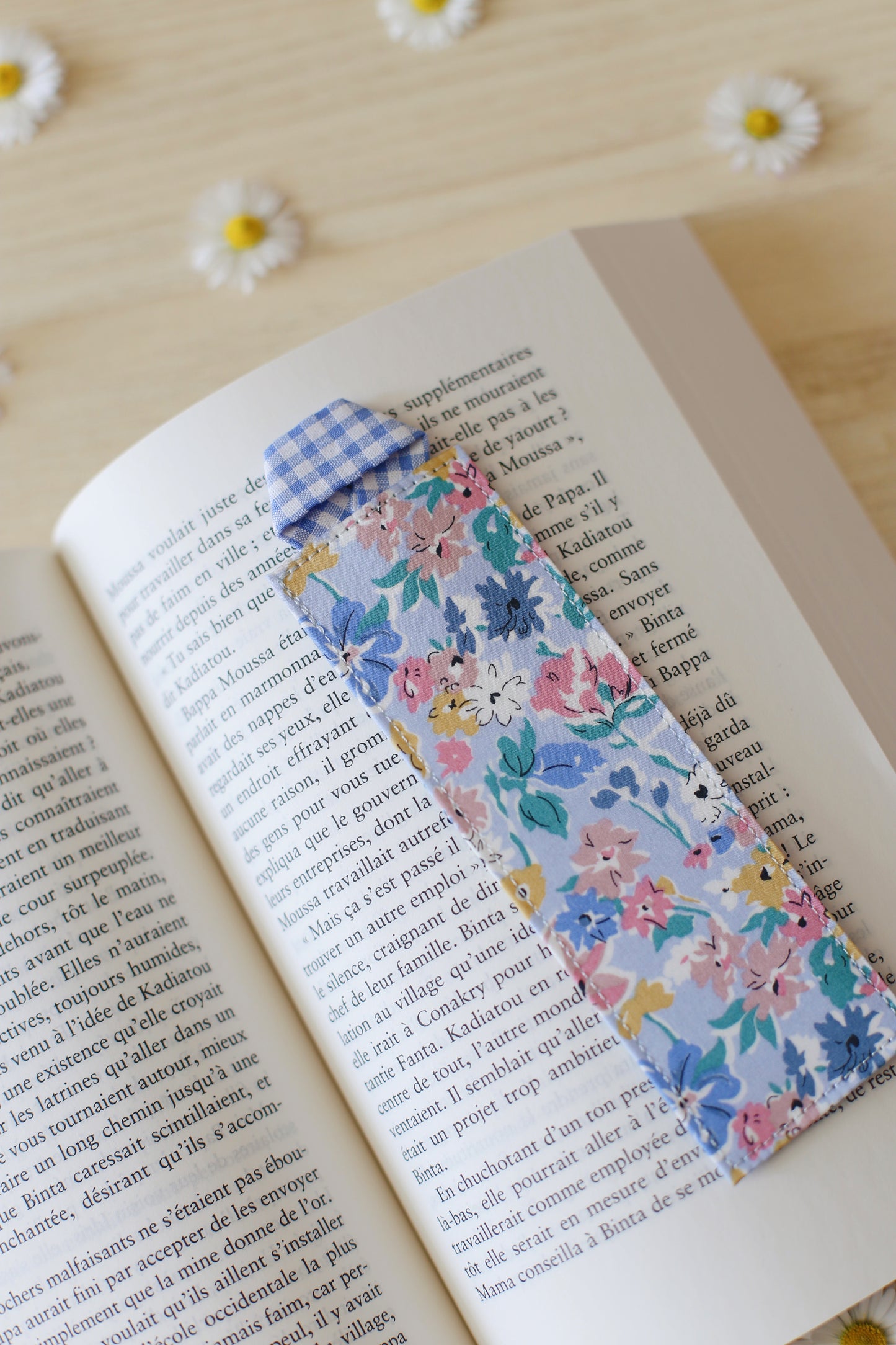 Marque-page artisanal Liberty of London bleu dans un livre ouvert - Où vivaient les gens heureux Joyce Maynard, fabrication française - Des fils et des mots